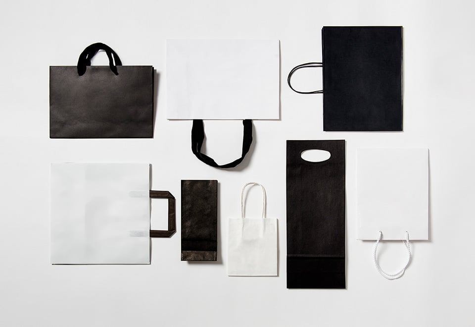 Flat lay of black and white paper bags. 