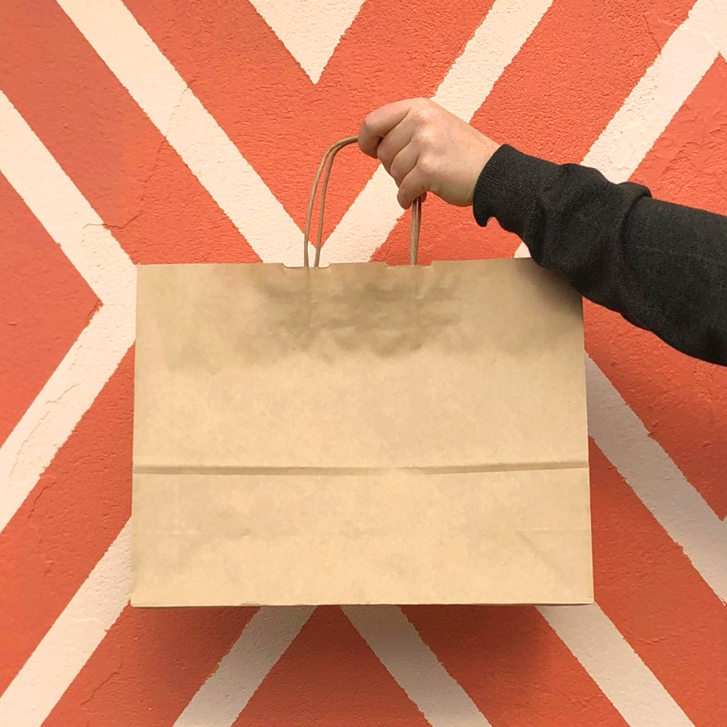 Image of paper bag with paper twist handle against a colourful wall