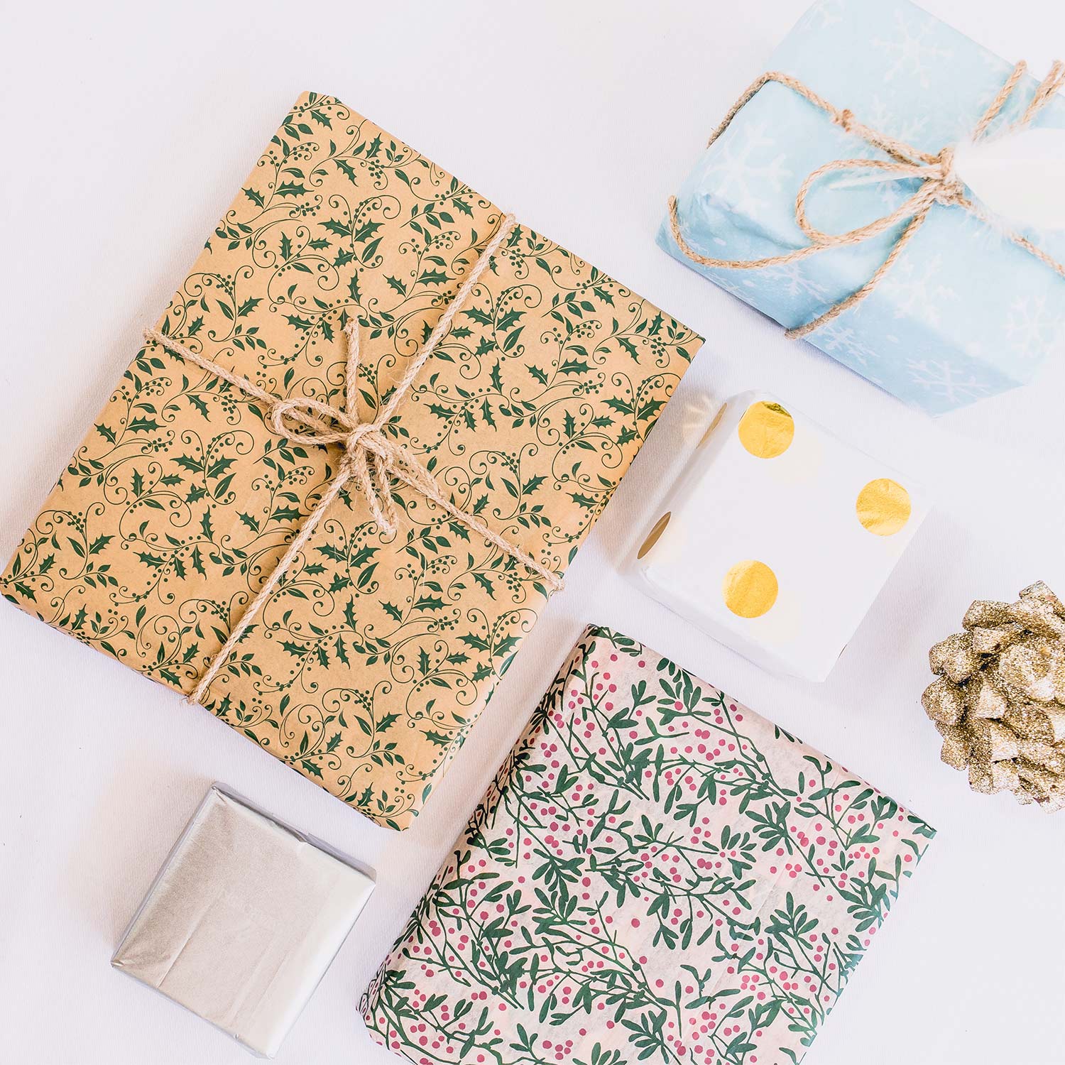 Image of four wrapped gifts in wrapping paper with different prints, two featuring jute string